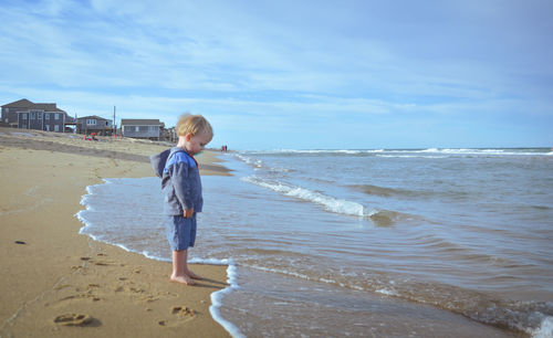 Full length of boy on beach against sky