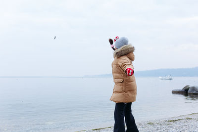 Rear view of woman standing on beach