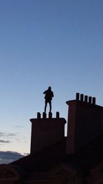 Low angle view of silhouette statue against clear sky