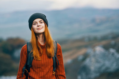 Young woman looking away while standing on mountain