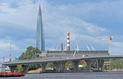 Bridge over river against sky in city