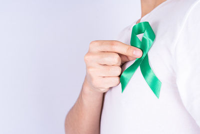 Close-up of man holding hands over white background