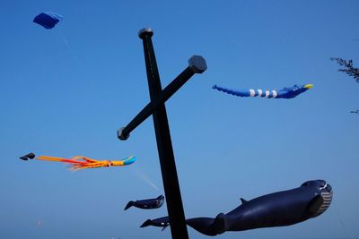 Low angle view of kite flying against clear blue sky