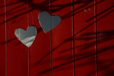 Close-up of heart shape on red door