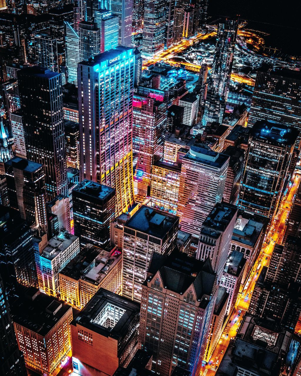 HIGH ANGLE VIEW OF ILLUMINATED CITY BUILDINGS