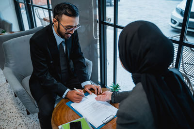 Side view of businessman using laptop while standing in office