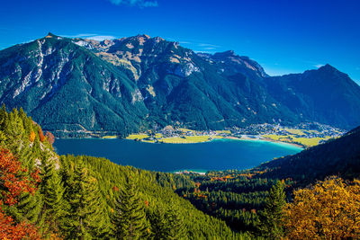 Scenic view of lake and mountains against blue sky