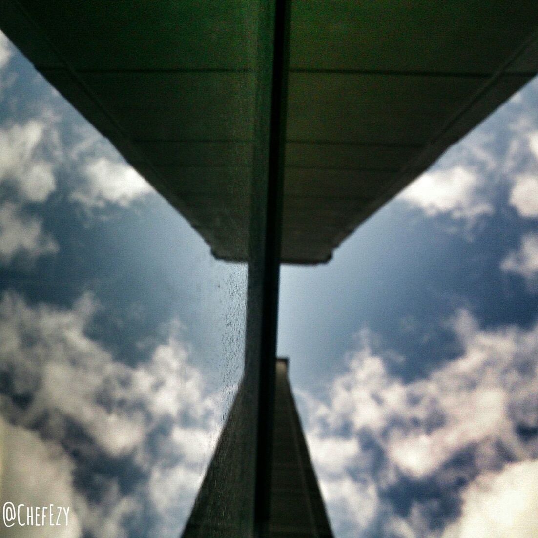 sky, architecture, built structure, cloud - sky, low angle view, cloudy, transportation, connection, cloud, diminishing perspective, engineering, bridge - man made structure, part of, no people, outdoors, the way forward, building exterior, day, vanishing point, travel
