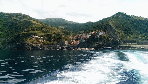 Scenic view of sea by buildings against sky