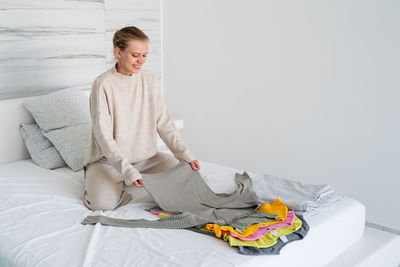 Woman sitting on bed at home