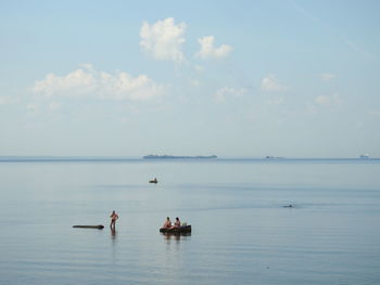 People on sea against sky