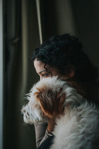 Close-up of woman holding dog at home