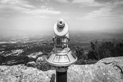 Coin-operated binoculars against sky in city