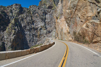 Road amidst rocky mountains against sky