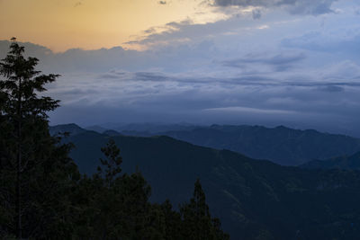 Scenic view of mountains against sky at sunset