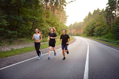 People running on road along trees
