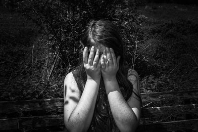 Portrait of a serious young woman covering face