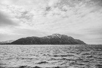 Scenic view of sea and mountains against sky