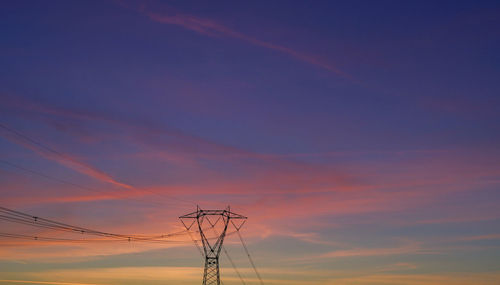 Low angle view of silhouette electricity pylon against sky during sunset