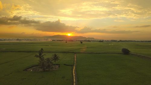 Scenic view of field against sky during sunset