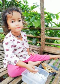 Portrait of cute girl sitting outdoors