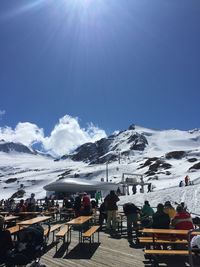 People on snowcapped mountain against sky