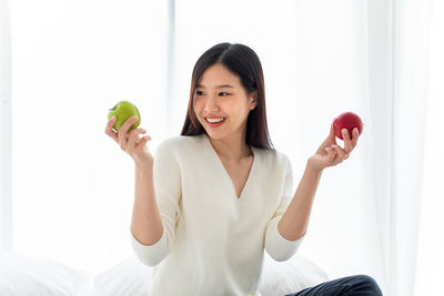 Portrait of happy woman holding apple