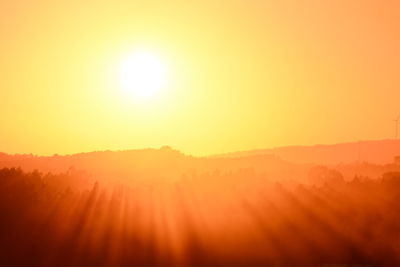 Scenic view of field against orange sky