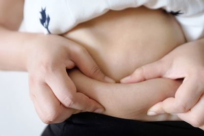 Midsection of woman holding her belly