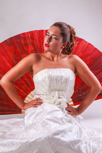 Portrait of bride sitting against white background