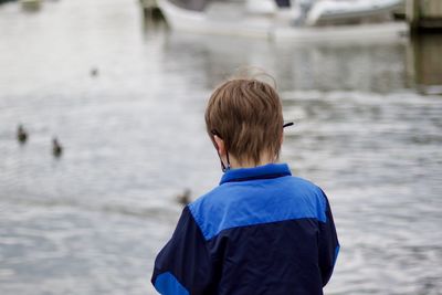 Rear view of boy looking at water