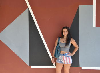 Portrait of beautiful woman standing against wall