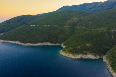 Scenic view of sea and mountains against sky