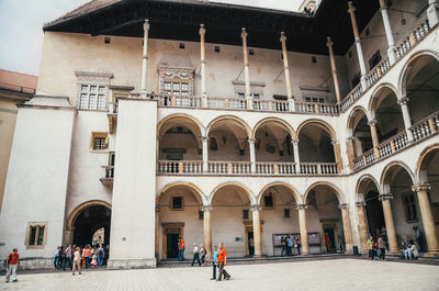 Group of people walking in front of arched structure