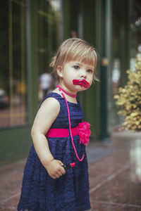 Portrait of cute girl looking away while standing outdoors