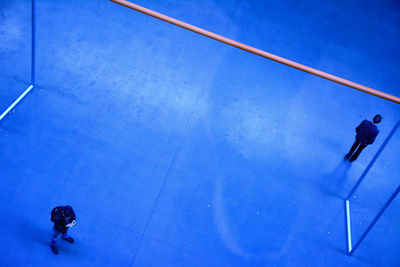 High angle view of people walking against blue sky
