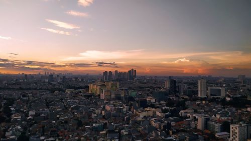 Aerial view of city against sky during sunset