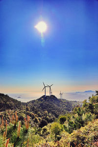 Wind turbines on land against sky