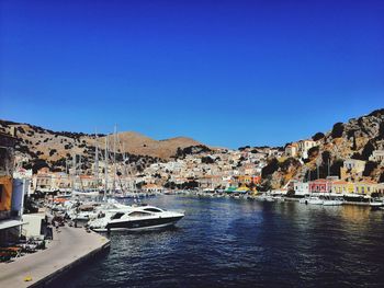 View of town by sea against clear blue sky