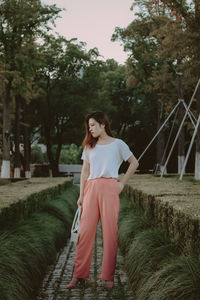 Full length of woman standing against trees