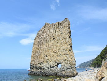 Rock formations in sea against sky