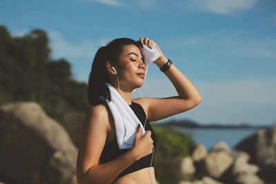 Side view of young woman standing against mountain