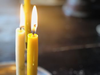 Close up of two burning candles on the wooden background with blurred background with copy space