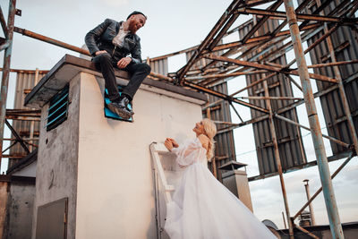 Low angle view of man playing with umbrella