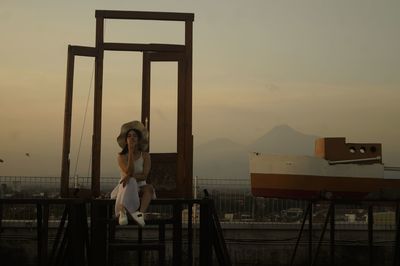 Rear view of woman sitting on table