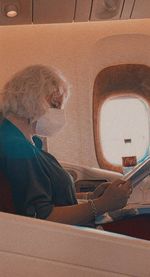 Side view of woman sitting in airplane