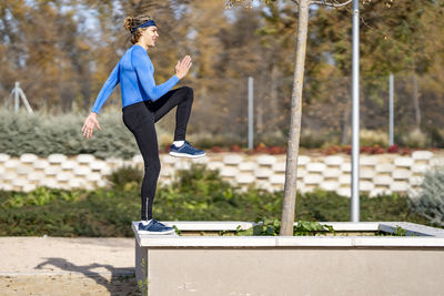 Side view of woman running against blurred background