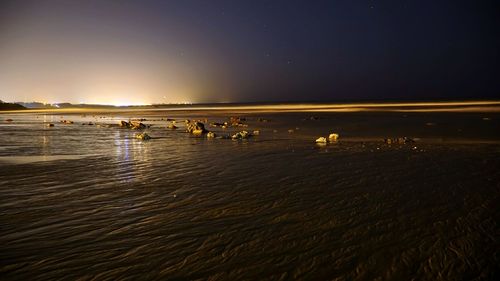Scenic view of lake against sky at night