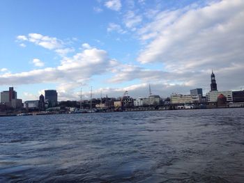 River in city against cloudy sky