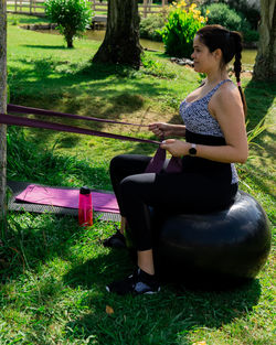 Side view of woman sitting on seat in field